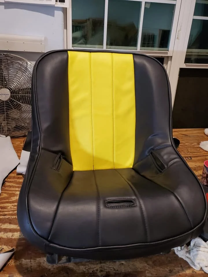 Custom vehicle seat after reupholstery in black with a bright yellow center panel