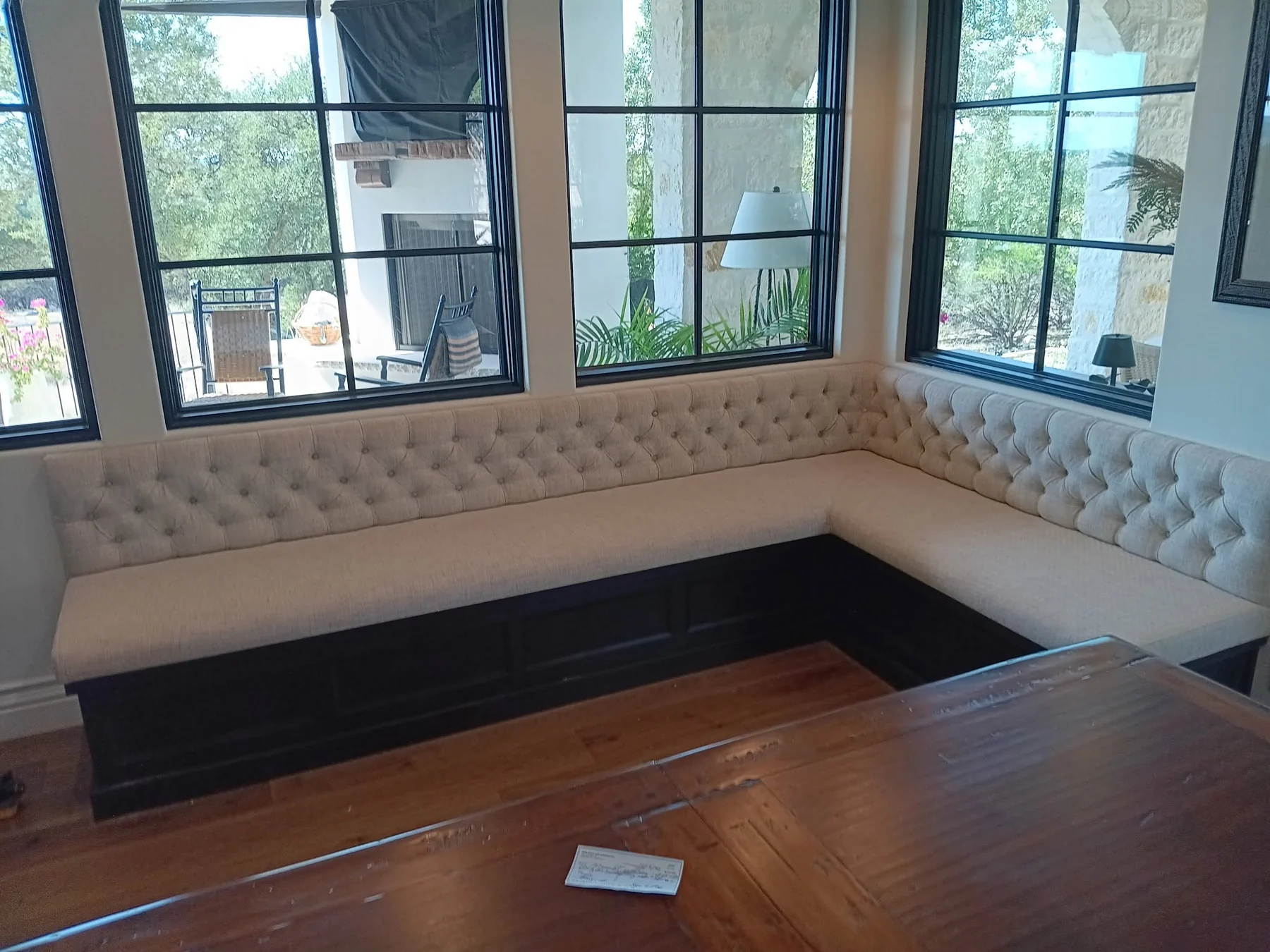 Complete cream L-shaped banquette beneath tall restaurant windows