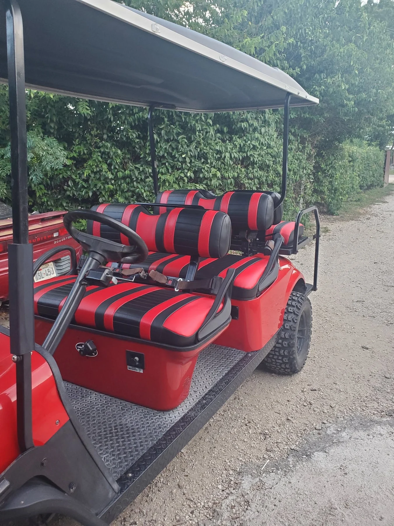 Red golf cart fitted with bold red-and-black striped seating