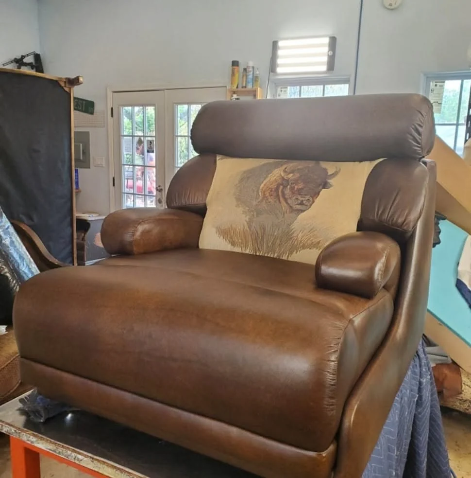 Brown leather recliner with padded arms and a tall headrest