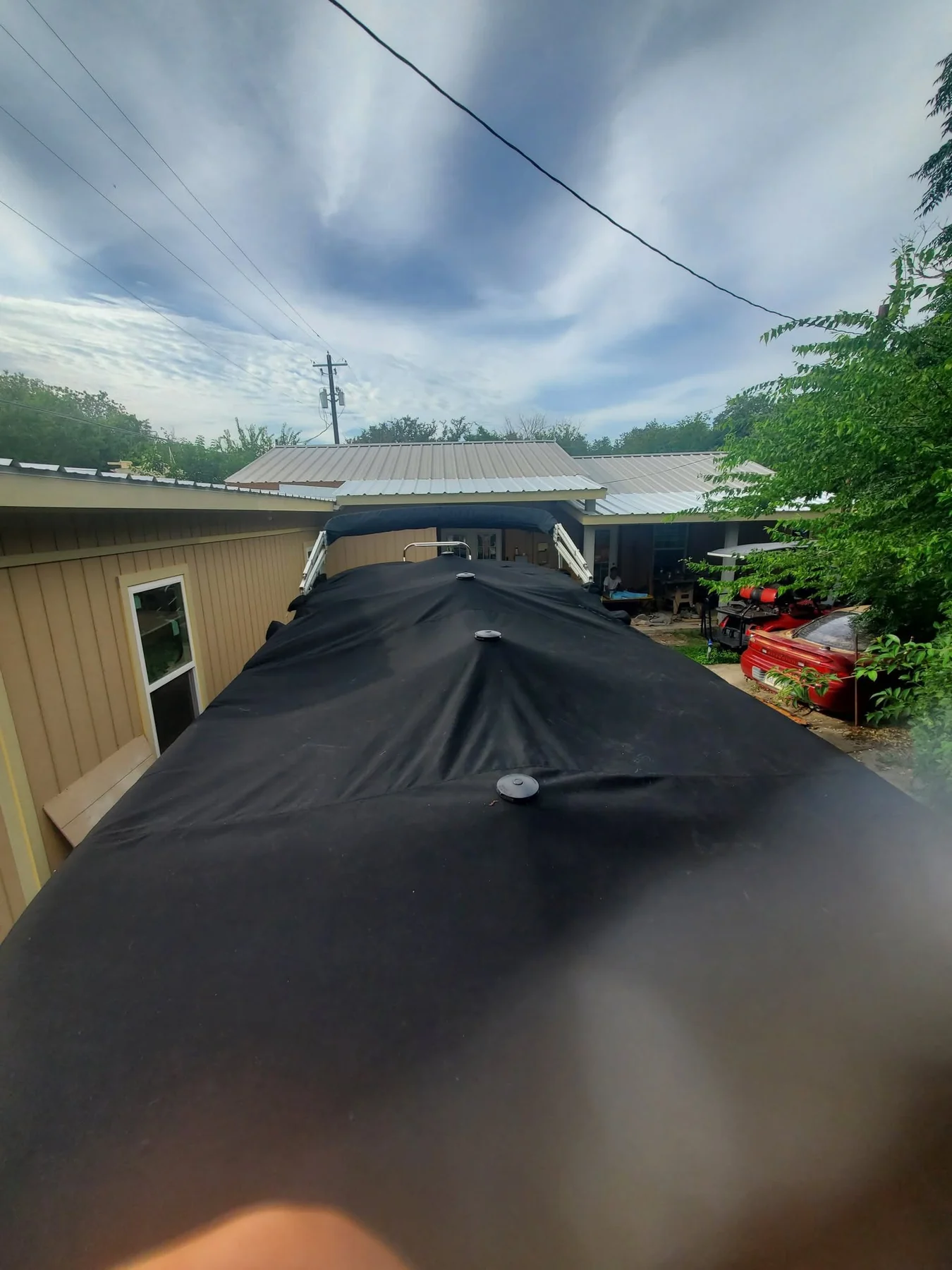 Close view of a fitted black marine cover over a long boat surface