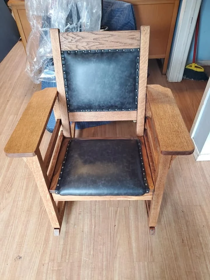 Vintage wood armchair after restoration with dark upholstered back and seat panels