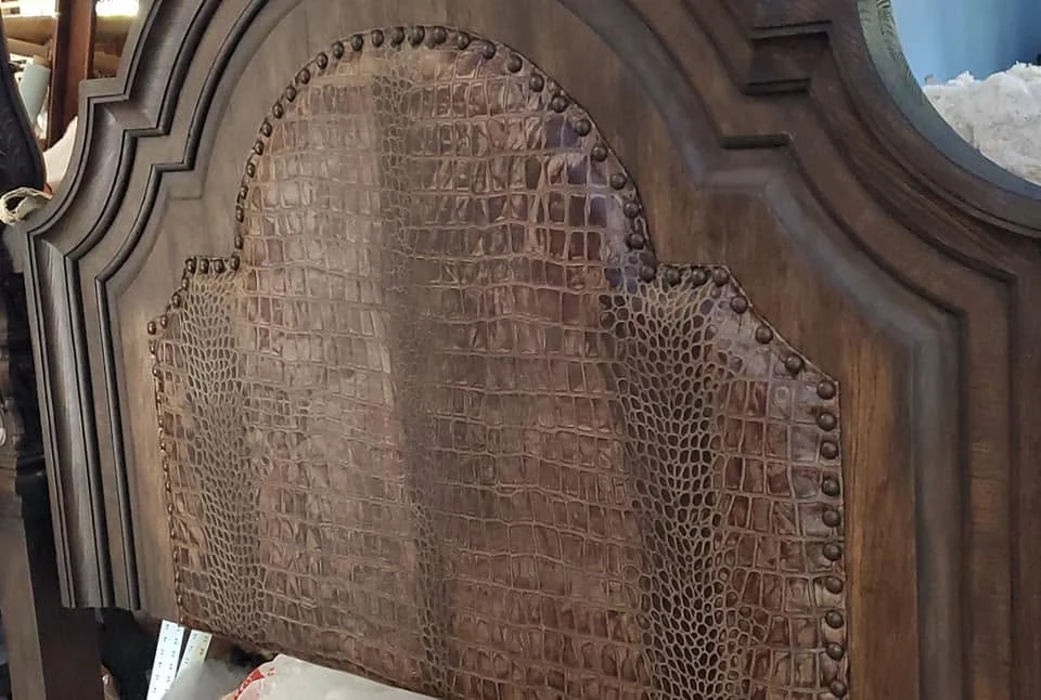 Carved arched chair back after restoration with textured brown woven upholstery